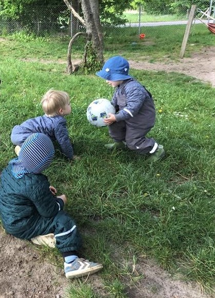 Billede af to små drenge fra vuggestuen, der spiller bold.