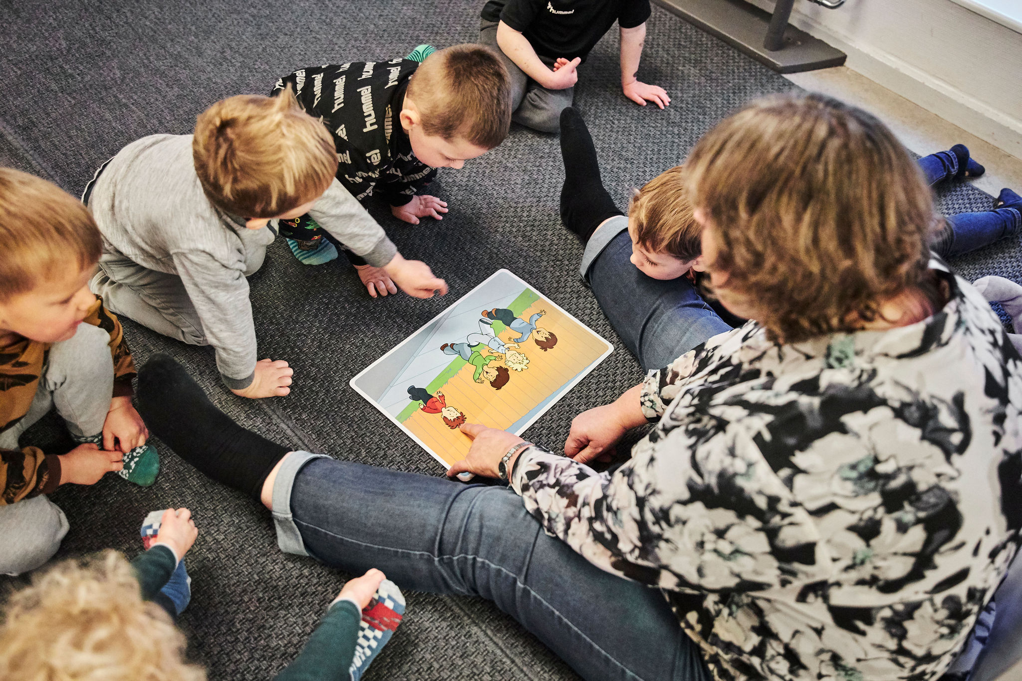 Billede af børnehavebørn, der sidder på gulvet og er optaget af at arbejde med Mary Fondens materiale "Fri for mobberi".